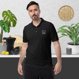 A man wearing an adidas performance polo shirt standing in front of a kitchen.